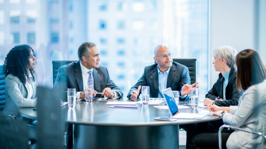 Business owner and management team discussing a management buyout (MBO)