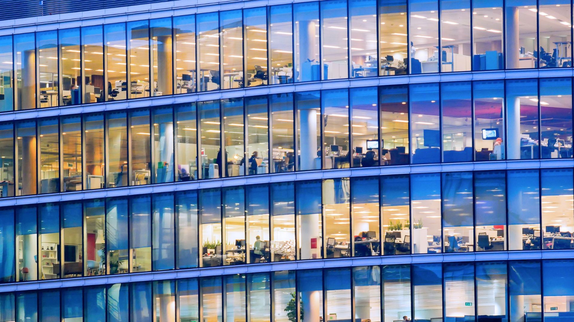 The exterior of a glass-sided office building during the work day